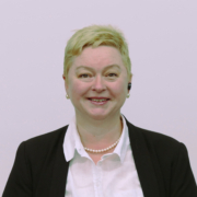 A smiling lady in office dress with short light hair
